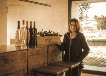 Ana Patrícia em pose para foto ao lado de vinhos na Itália