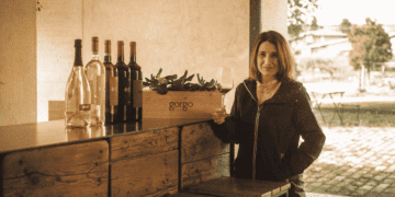Ana Patrícia em pose para foto ao lado de vinhos na Itália