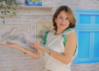 Ana Patrícia em seu escritório com gesto de estar mostrando algo