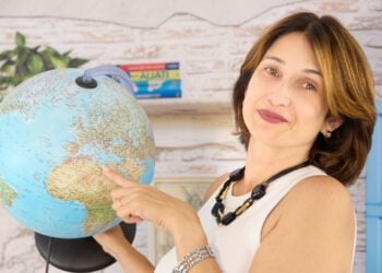 Ana Patrícia em seu escritório segurando globo terrestre