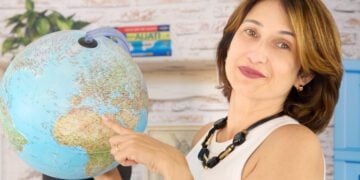 Ana Patrícia em seu escritório segurando globo terrestre