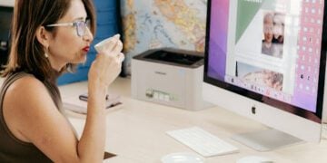 Ana tomando café enquanto monta roteiro de viagem para Itália